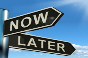 Signpost showing now or later - procrastination